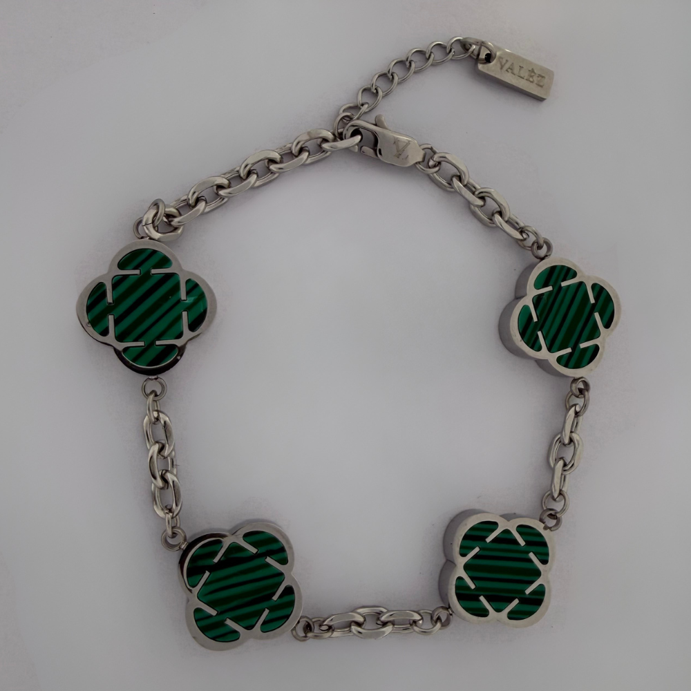 stainless steel bracelet with green clover-shaped links on a white background
