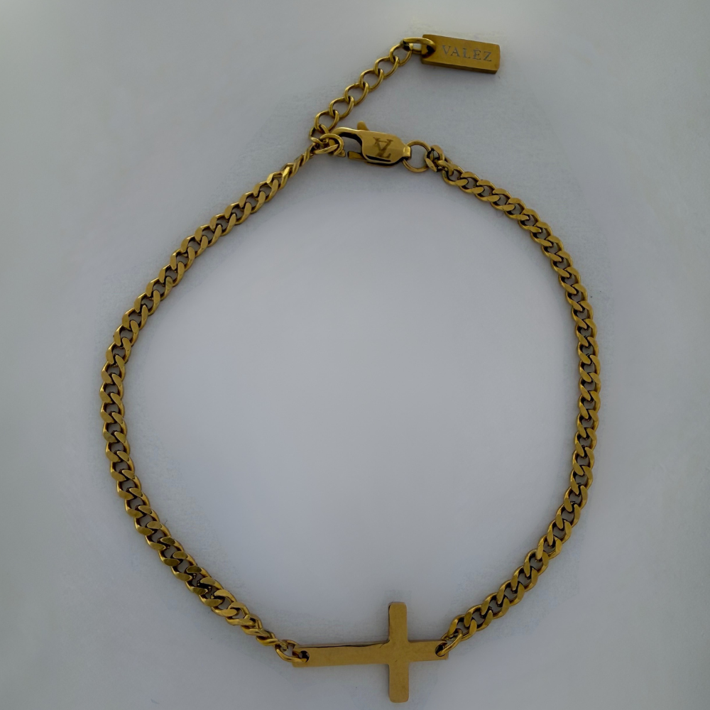 Gold cross bracelet on a white background