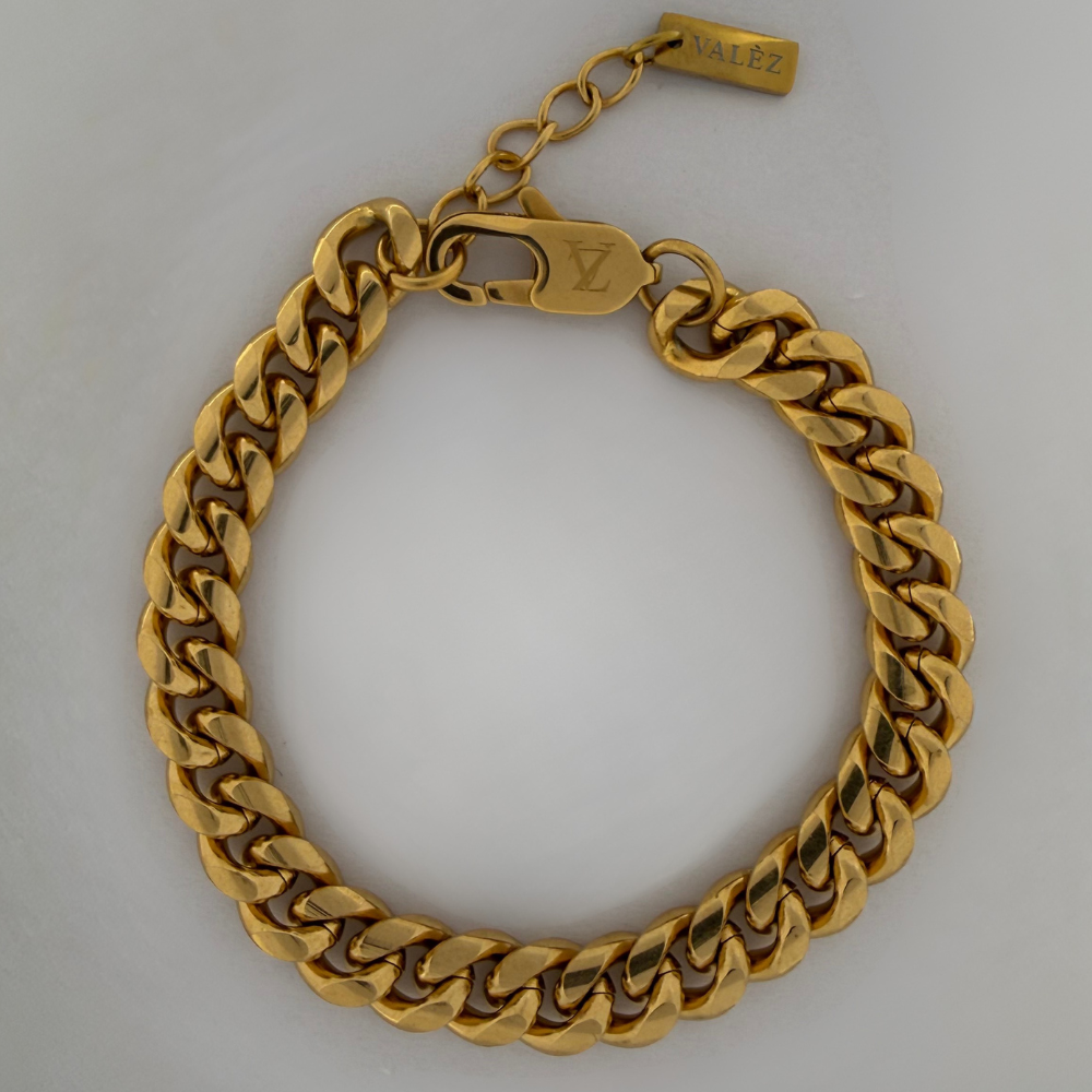 Gold cuban bracelet on a light gray background