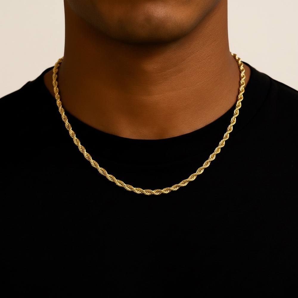 Gold rope chain necklace on a person wearing a black shirt against a beige background