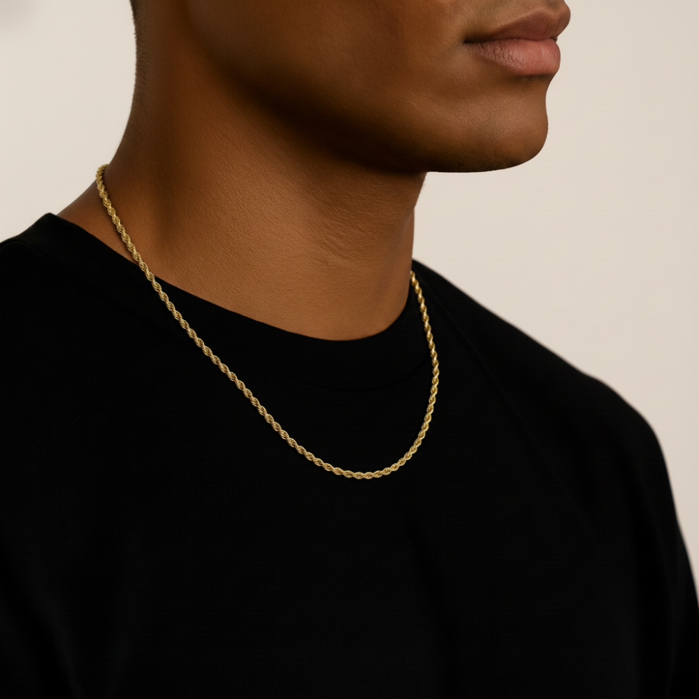 Person wearing a gold rope chain necklace against a neutral background