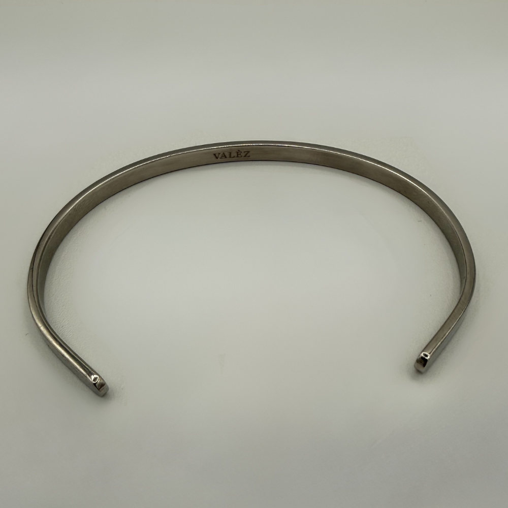 Stainless steel cuff bracelet on a light gray background