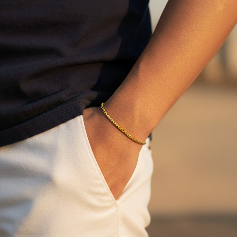 Close-up of a person wearing a gold Box bracelet with a blurred background