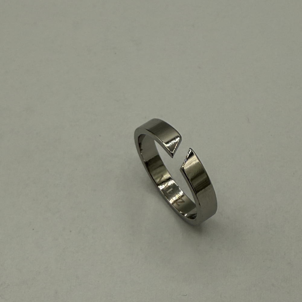 stainless steel ring with geometric design on a light gray background