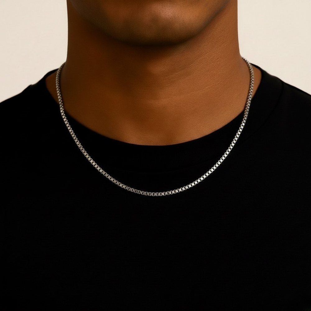 Stainless Steel chain necklace on a person wearing a black shirt against a beige background