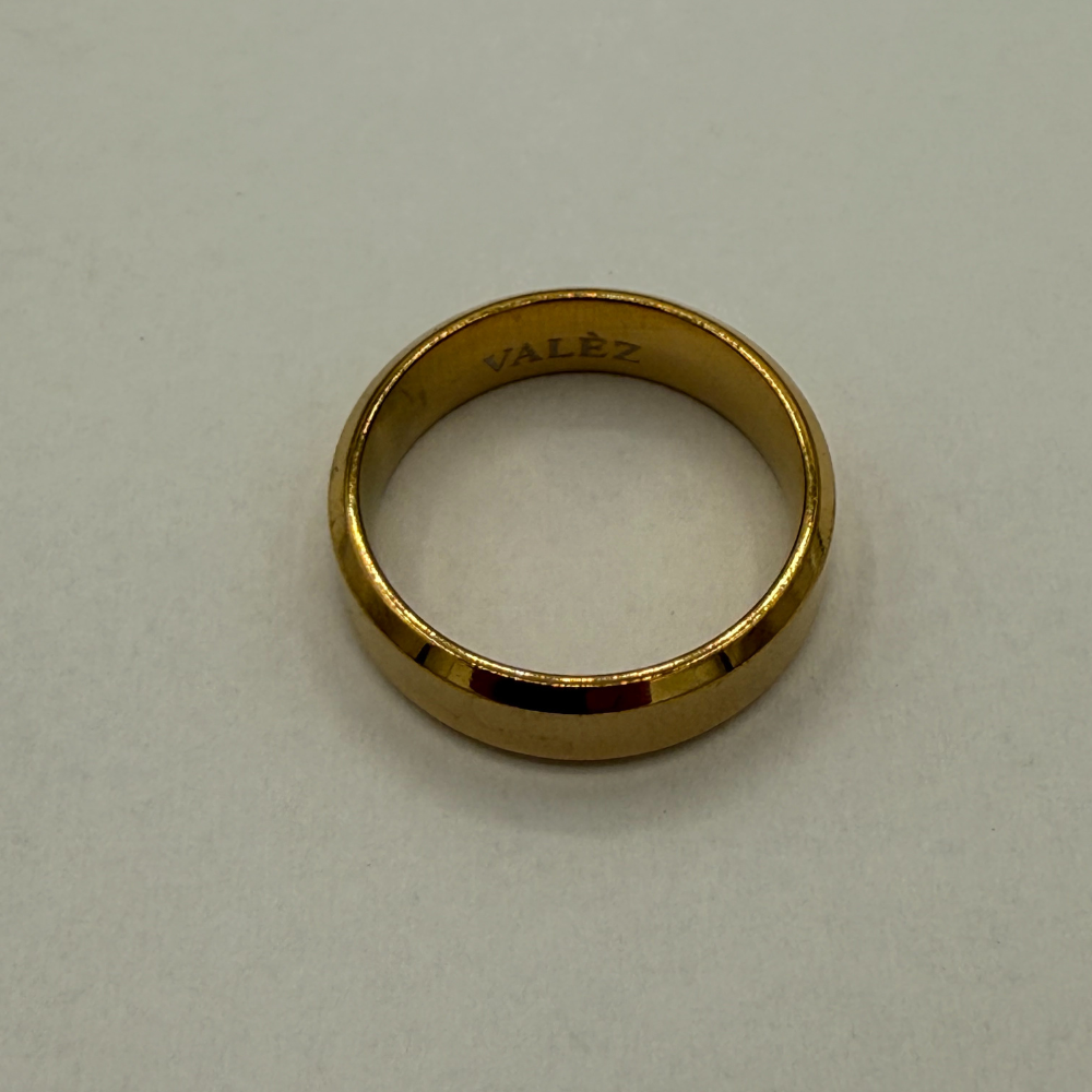 Gold ring with 'Valèz' engraving on a light gray background