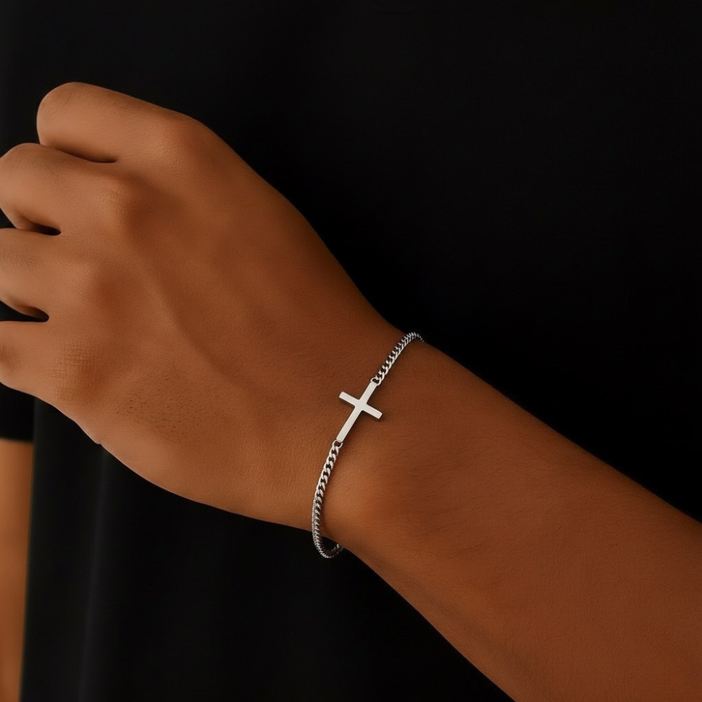 Stainless steel bracelet with a cross on a wrist against a black background