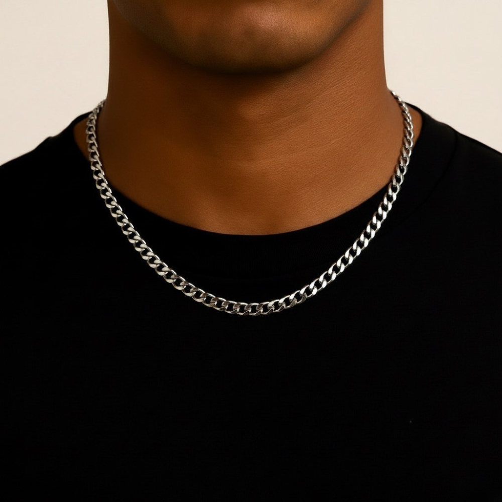 stainless steel chain necklace on a person wearing a black shirt against a beige background