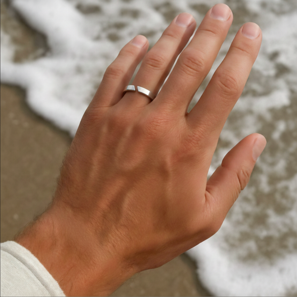 Hand with a ring on a blurred natural background