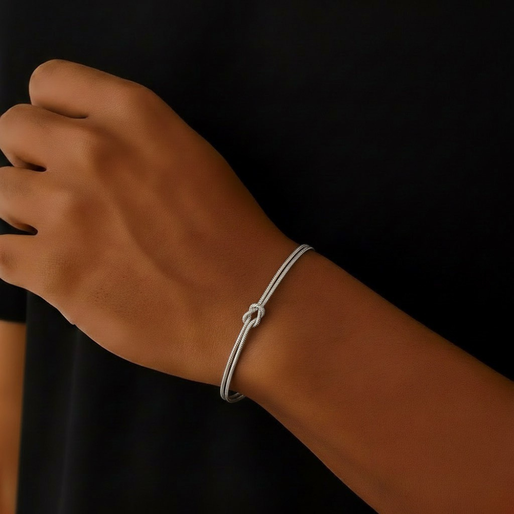 Stainless Steel Infinity bracelet on a wrist against a black background