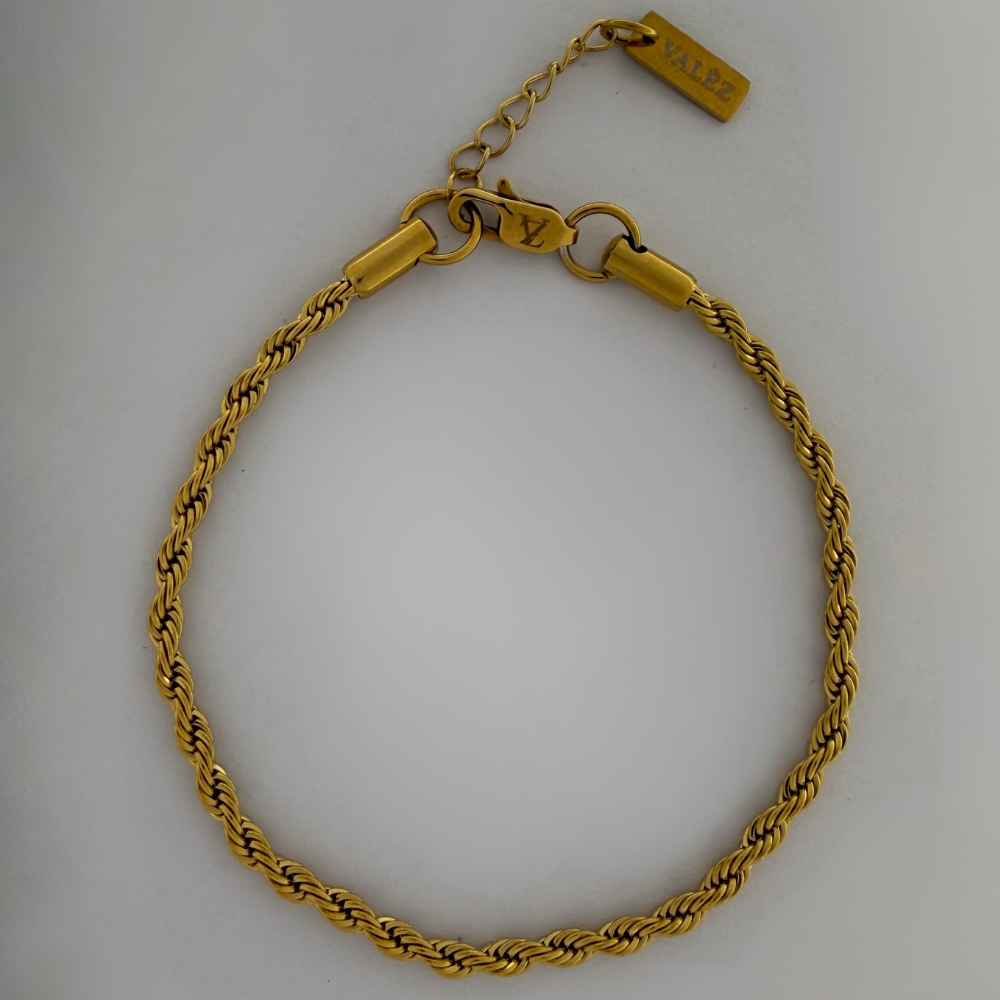 Gold rope bracelet on a light gray background