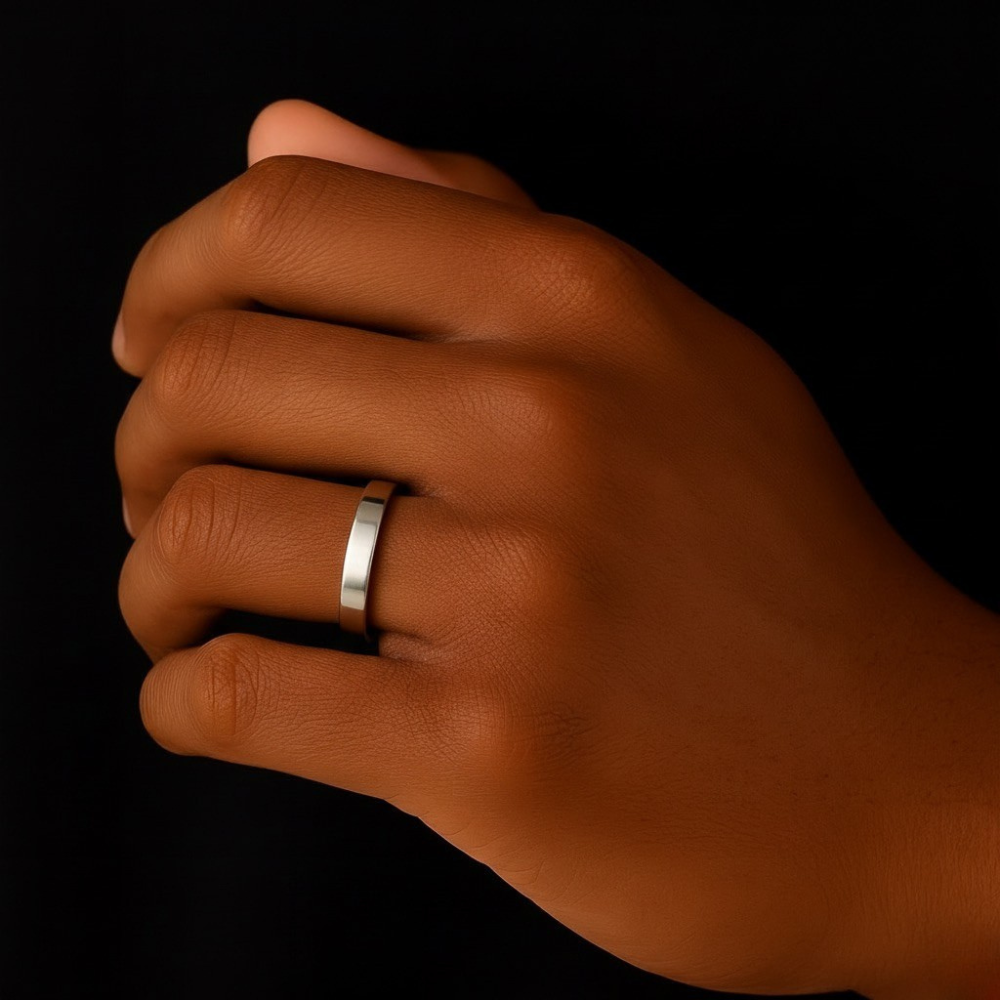 Hand wearing a stainless steel ring on a black background