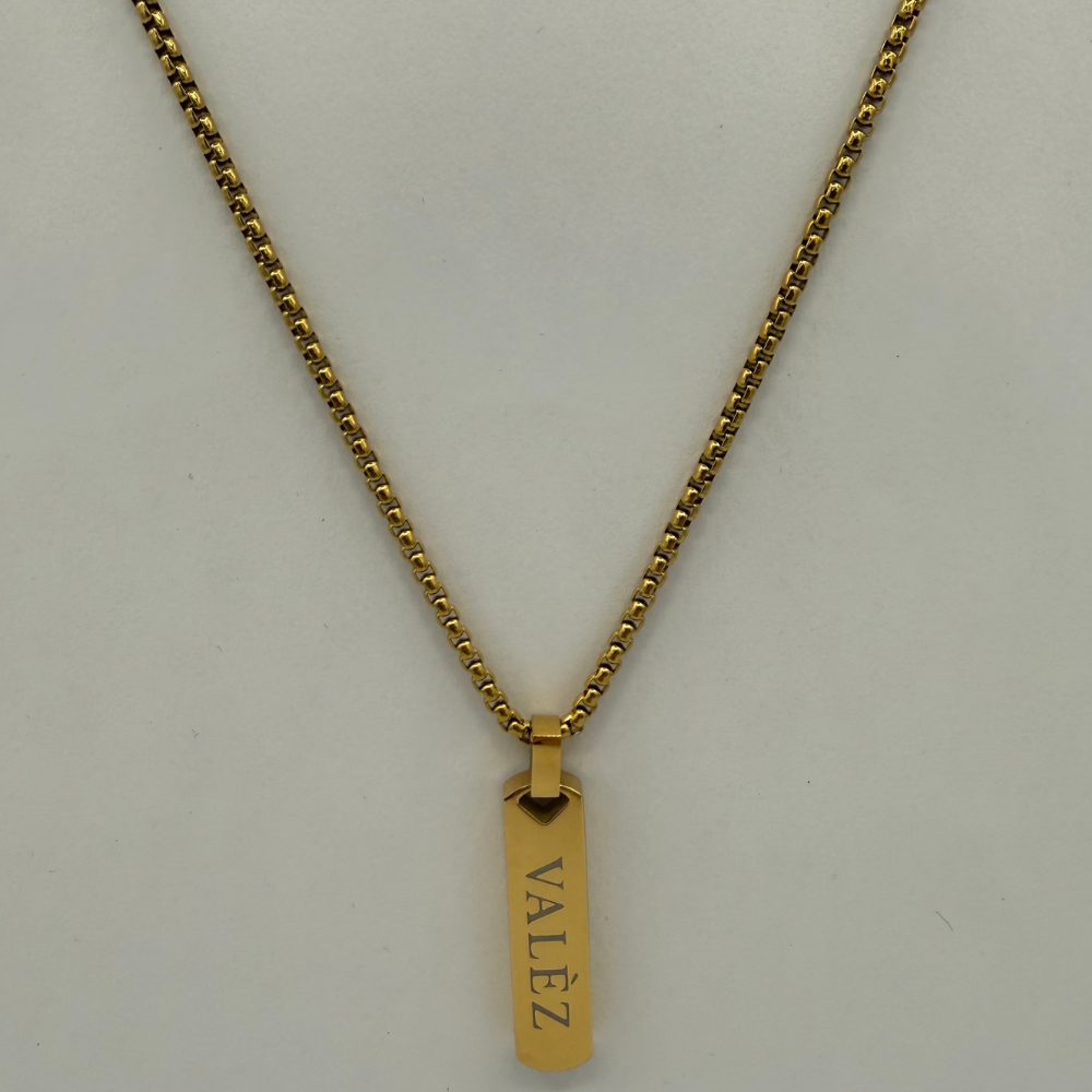 Gold necklace with a pendant on a light gray background