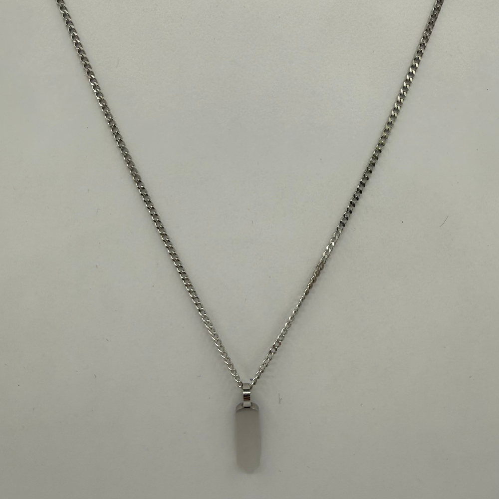 Stainless steel necklace with a plain pendant on a light gray background
