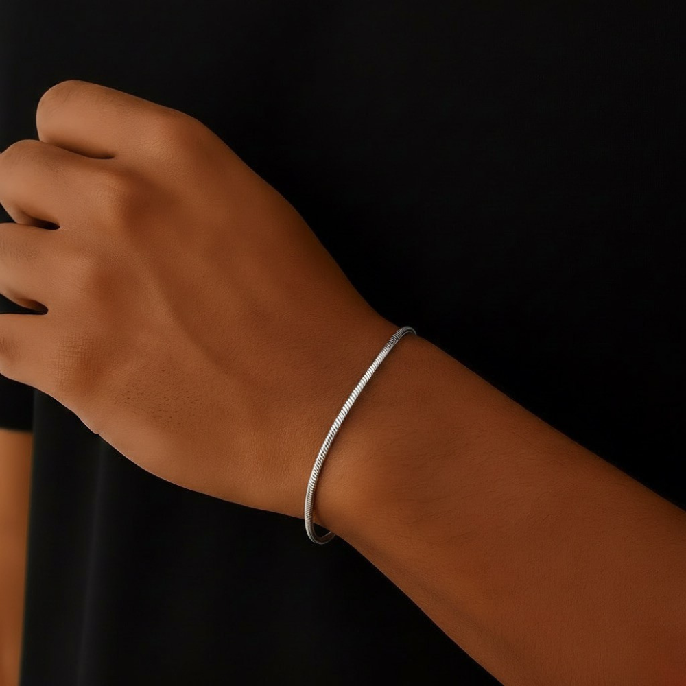 Stainless steel square bracelet on a wrist against a black background